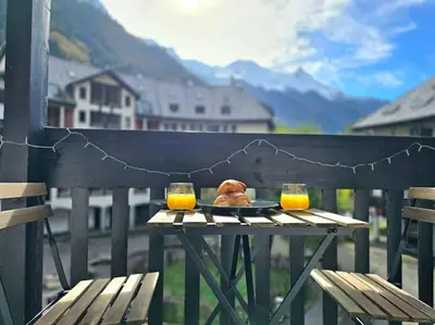 a plate of food on a table with two glasses of orange juice at Studio avec balcon vue MontBlanc et parking gratuit le nid daigle in Chamonix-Mont-Blanc
