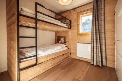 a bedroom with bunk beds in a wooden cabin at Appartement Margot - All the comforts with a view of Mont Blanc in Combloux