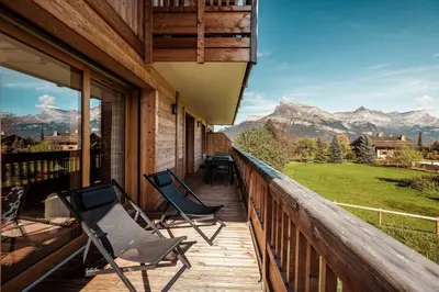 a porch with chairs and a view of mountains at Appartement Margot - All the comforts with a view of Mont Blanc in Combloux