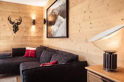 a living room with a couch and a lamp at Appartement Margot - All the comforts with a view of Mont Blanc in Combloux