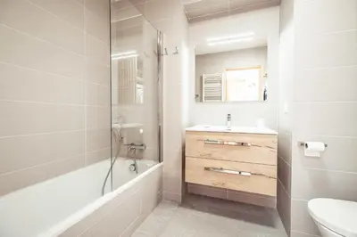 a bathroom with a tub and a sink and a toilet at Appartement Margot - All the comforts with a view of Mont Blanc in Combloux