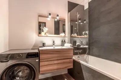 a bathroom with a washing machine and a sink at Cristal des Glaces - Balcon avec vue imprenable in Chamonix-Mont-Blanc