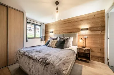 a bedroom with a bed and a wooden wall at Chalet Ikigai Chamonix - by EMERALD STAY in Chamonix-Mont-Blanc