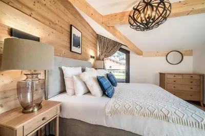 a bedroom with a bed and a chandelier at Chalet Ikigai Chamonix - by EMERALD STAY in Chamonix-Mont-Blanc