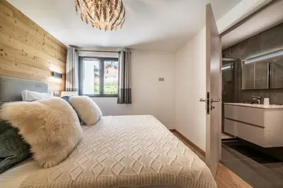a bedroom with a bed and a chandelier at Chalet Ikigai Chamonix - by EMERALD STAY in Chamonix-Mont-Blanc