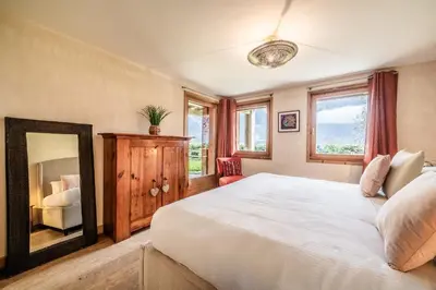 a bedroom with a large white bed and a mirror at Chalet Ibex Les Houches Chamonix - by EMERALD STAY in Les Houches