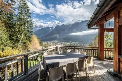 a table on a deck with a view of mountains at Chalet Ibex Les Houches Chamonix - by EMERALD STAY in Les Houches