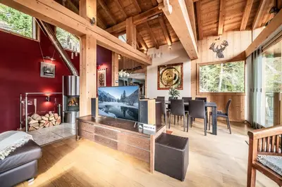 a living room with a large flat screen tv and a fireplace at Chalet Ibex Les Houches Chamonix - by EMERALD STAY in Les Houches