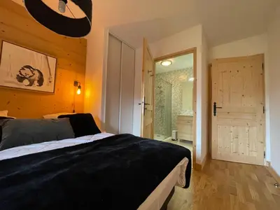 a bedroom with a bed and a door to a bathroom at Appartement lumineux avec balcons, WIFI et parking à Samoëns - FR-1-624-172 in Samoëns