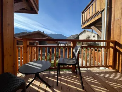 a balcony with a chair and a table on a deck at Appartement lumineux avec balcons, WIFI et parking à Samoëns - FR-1-624-172 in Samoëns