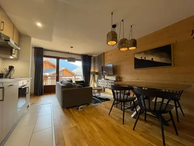 a kitchen and living room with a table and chairs at Appartement lumineux avec balcons, WIFI et parking à Samoëns - FR-1-624-172 in Samoëns