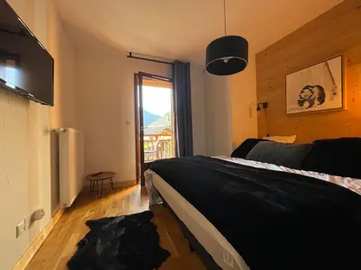 a bedroom with a bed and a large window at Appartement lumineux avec balcons, WIFI et parking à Samoëns - FR-1-624-172 in Samoëns