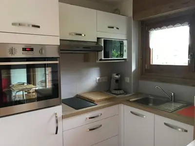 a kitchen with white cabinets and a sink and a window at Studio 4 pers, skis aux pieds, lave-vaisselle, lave-linge, balcon - FR-1-572-299 in Arâches-la-Frasse