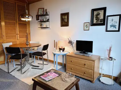 a living room with a table and a tv on a cabinet at Blanches Alpes Appartement Megève in Megève