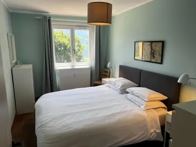 a bedroom with a large white bed with a window at Vue du Mont-Blanc in Passy