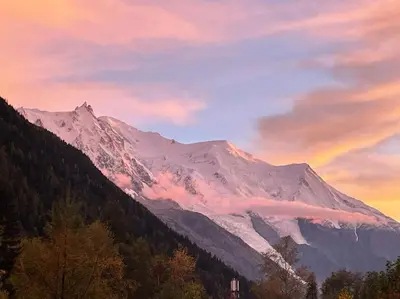 a snow covered mountain with a rainbow in the sky at Duplex 4 pers vue MontBlanc , Grands Montets in Chamonix-Mont-Blanc