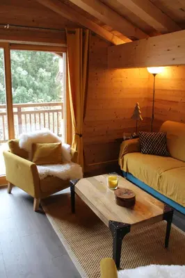a living room with a bed and a chair and a coffee table at Appartement de standing Chalet Bostan in Samoëns