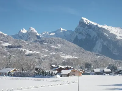 a snow covered mountain range with a village and houses at Appartement de standing Chalet Bostan in Samoëns