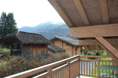 a porch of a cabin with a wooden deck at Appartement de standing Chalet Bostan in Samoëns