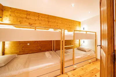 two bunk beds in a room with a wooden wall at Alpine Garden - Truly hidden gem with sunny garden in Chamonix town center in Chamonix-Mont-Blanc