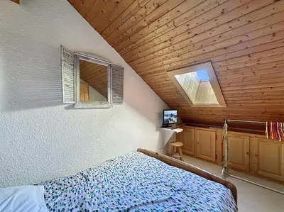 a bedroom with a bed and a wooden ceiling at ob219 4 pieces duplex 6 personnes proche pistes in Les Carroz d'Araches