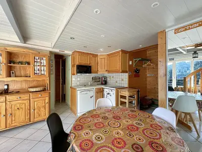 a kitchen with a table and a kitchen with a table and chairs at ob219 4 pieces duplex 6 personnes proche pistes in Les Carroz d'Araches