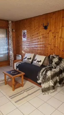 a living room with a bed and a table at Chaleureux refuge thermal in Saint-Gervais-les-Bains