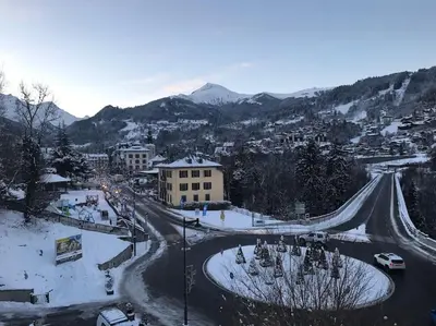 a snow covered city with a road and a mountain at Appart cosy et lumineux au cœur de Saint Gervais in Saint-Gervais-les-Bains