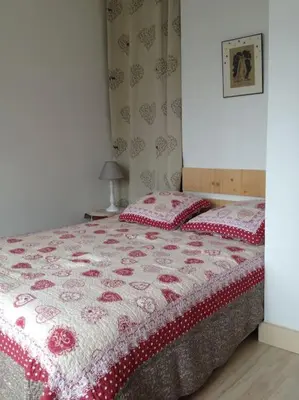 a bedroom with a bed with a red and white quilt at Appart cosy et lumineux au cœur de Saint Gervais in Saint-Gervais-les-Bains