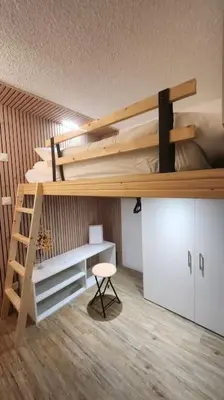 a bedroom with a bunk bed with a desk and a ladder at Cocon Face au MontBlanc in Sallanches