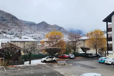 a parking lot with cars parked in front of a mountain at Cocon Face au MontBlanc in Sallanches