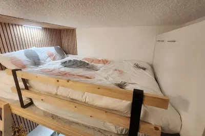 a bedroom with a bed with a wooden frame at Cocon Face au MontBlanc in Sallanches
