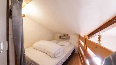 a bed with white sheets on it in a attic at Grand Horizon 2 301 - 3P8 in Morillon
