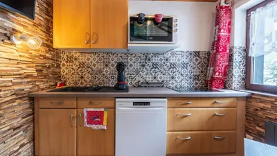 a kitchen with wooden cabinets and a white dishwasher at Grand Horizon 2 301 - 3P8 in Morillon