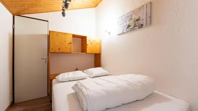 a bedroom with a bed with white sheets and a mirror at Grand Horizon 2 301 - 3P8 in Morillon