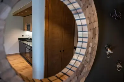 a mirror in a kitchen with a wooden door at Exclusive accommodation terrace, parking and pool in Megève