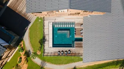 an overhead view of a building with a swimming pool at Exclusive accommodation terrace, parking and pool in Megève