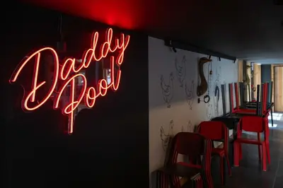 a neon sign for a barber shop with red chairs at Exclusive accommodation terrace, parking and pool in Megève