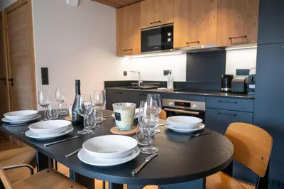 a kitchen with a table with plates and wine glasses at Exclusive accommodation terrace, parking and pool in Megève