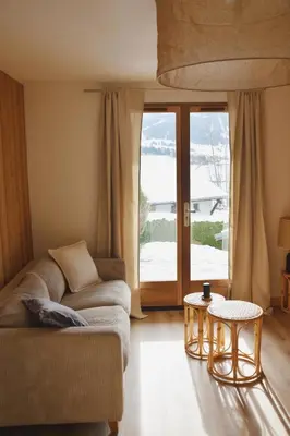 a living room with a couch and a table at Chez Colette - Appartement à la montagne in Demi-Quartier