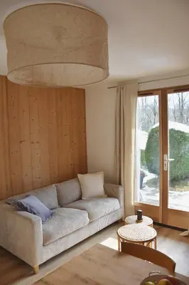 a living room with a couch and a table at Chez Colette - Appartement à la montagne in Demi-Quartier