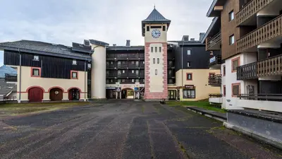 an empty parking lot with a clock tower on a building at Grand Morillon 212 - 2P5 in Morillon
