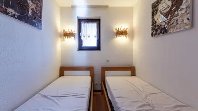 two beds in a small room with a window at Grand Morillon 212 - 2P5 in Morillon