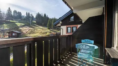 a balcony with a blue chair and a view at Grand Morillon 212 - 2P5 in Morillon