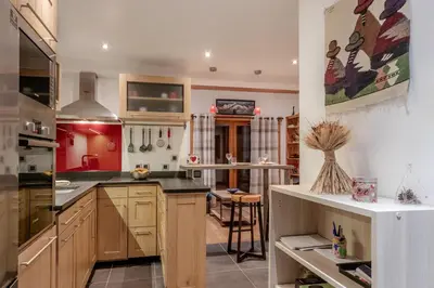 a large kitchen with wooden cabinets and a counter top at La Cremaillere in Sallanches