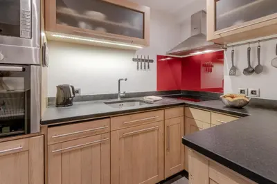 a large kitchen with wooden cabinets and a sink at La Cremaillere in Sallanches