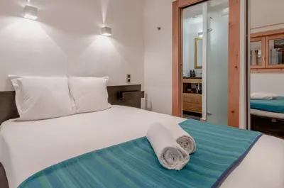 a bedroom with a white bed with towels on it at La Cremaillere in Sallanches