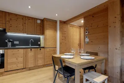 a dining room with a table and chairs and wooden walls at Jardin du Brevent in Chamonix-Mont-Blanc