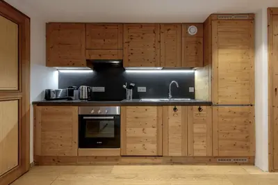 a kitchen with wooden cabinets and a sink at Jardin du Brevent in Chamonix-Mont-Blanc