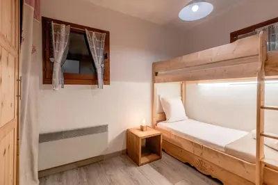 a bedroom with a bunk bed and a candle on a table at Jardin du Mont Blanc in Chamonix-Mont-Blanc